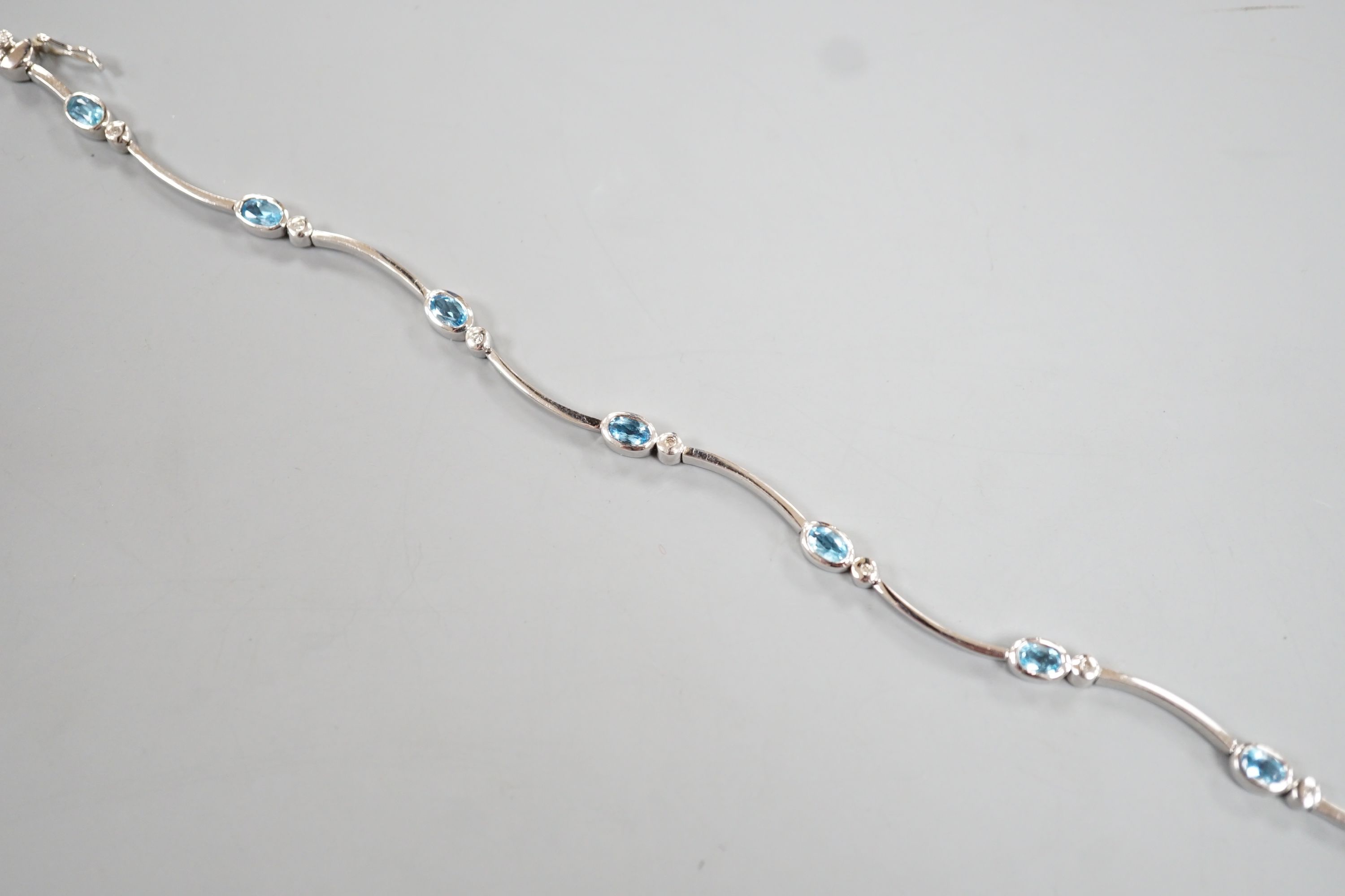 A modern 9ct white gold, blue topaz? and diamond chip set bracelet, 18.5cm, gross 8.8 grams.